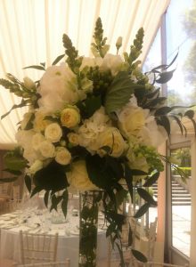 Image of a tall floral arrangement in white and cream tones by Adonis