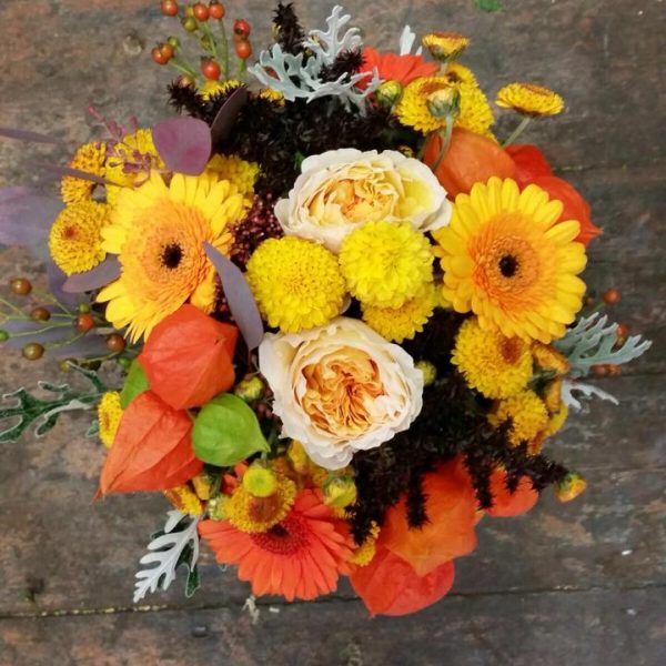 Image of an autumnal wedding arrangement in rich orange and yellow tones