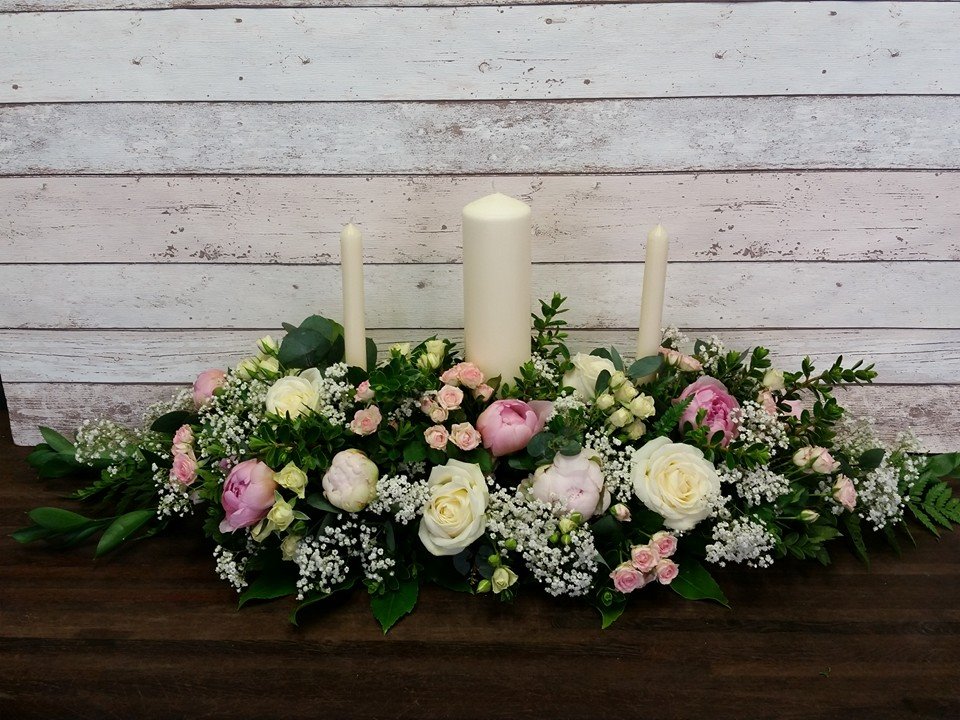 image of a unity arrangement featuring white roses and pink peonies and pillar candles