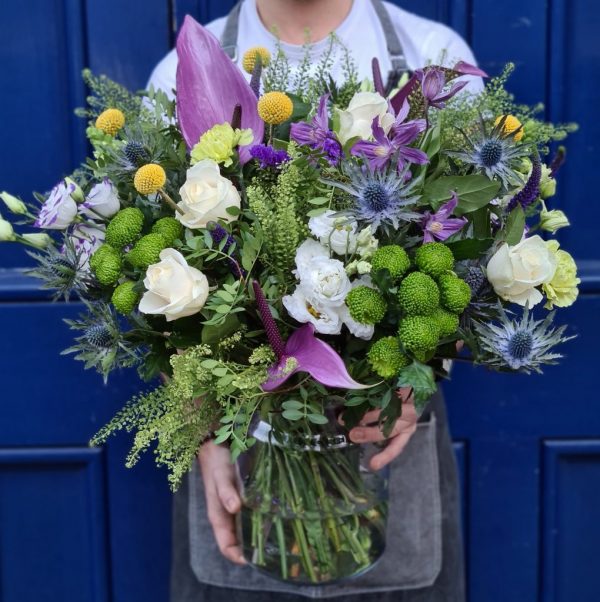 Image of the Eco friendly Florists choice bouquet in a vase, featuring a generous bouquet made to the florists daily pick