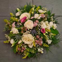 image of a small funeral posy wreath by Adonis presented in a rustic garden style