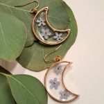 image of hand crafted moon shaped earrings with small blue flowers by Irish supplier prickle and plum