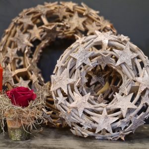 image of two wooden ringed wreaths decorated with natural birch stars, the small is washed white and the larger is natural wood tones.