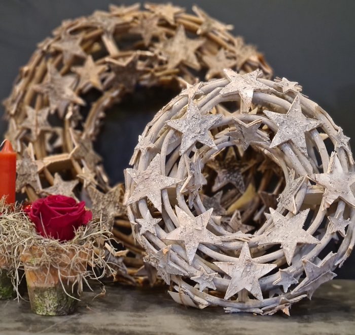 image of two wooden ringed wreaths decorated with natural birch stars, the small is washed white and the larger is natural wood tones.